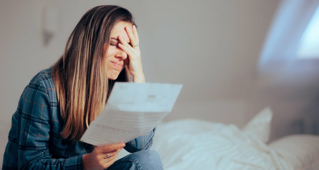 Frau sieht dokument mit hohen Klarnaschulden